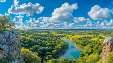 Obraz premium A panoramic view of a lush landscape with a winding river and blue sky.
