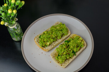 Avocado Toast on a bread roll, sprinkled with dried chili