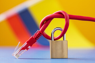A closed lock on a tied network wire in a knot on the background of the Colombia flag, concept of security of Internet technologies in the country