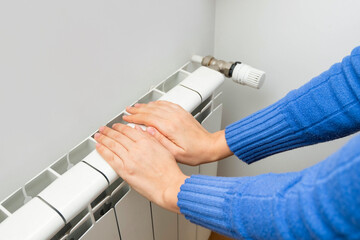 Hands adjusting modern radiator thermosta