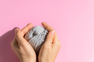 Obraz premium Ball of pink yarn on light background