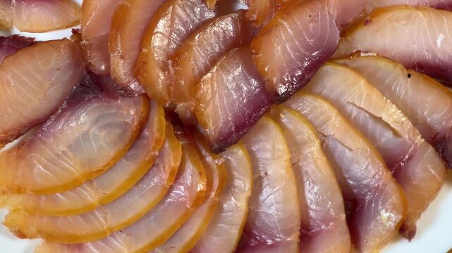Sliced different cold smoked freshwater fish on plate, top view