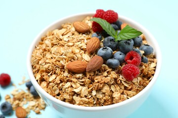 Delicious granola with berries on a color background