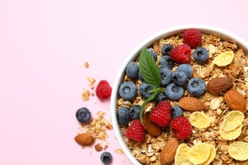 Delicious granola with berries on a color background