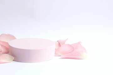 Pink rose petals with podium on a white background