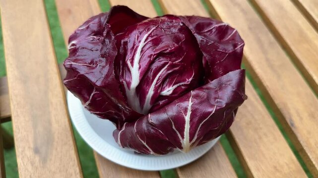 Head of radicchio on white dish on a wooden table