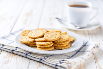 Round crackers and coffee on a white table, selective focus.