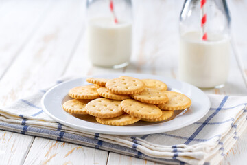 Wheat round crackers and bottles of fresh milk on a light kitchen table,healthy breakfast.