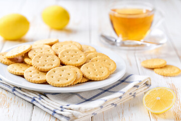 Wheat round crackers and tea on a white table, selective focus.