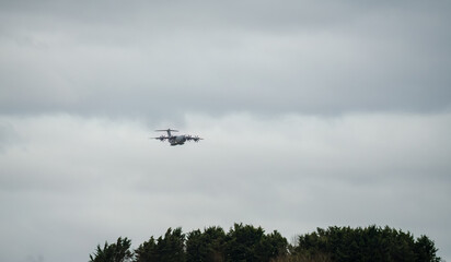 ZM401 RAF Royal Air Force Airbus C.1 A400M Atlas military transport plane in flight, on approach to a low-level cargo parachute drop exercise, light cloud sky