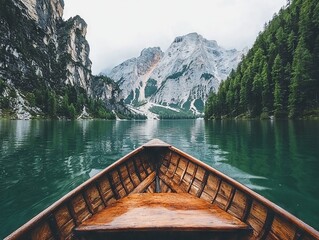 A serene view from the bow of a wooden boat on a tranquil lake surrounded by mountains.
