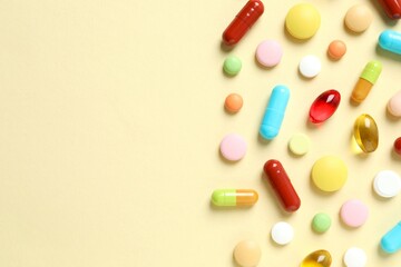 Various pills and capsules on a color background