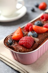 Delicious tiramisu cake with berries on table