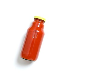 Tomato juice in a glass bottle on white background