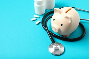 Piggy bank with stethoscope on color background. Health care financial checkup or saving for...