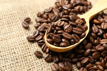 Wooden spoon with coffee beans on burlap