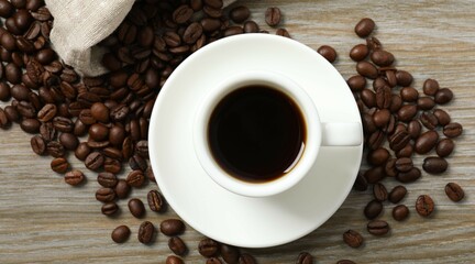 Cup of coffee and coffee beans on wooden background