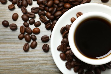 Cup of coffee and coffee beans on wooden background