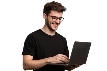 A smiling man with glasses wearing a black shirt, standing and holding and looking down at a laptop on a transparent, isolated background