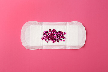 Menstrual pad with sequins on pink background, top view