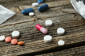 Drug addiction. Different pills on wooden table, closeup