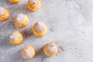 Homemade profiteroles with powdered sugar.