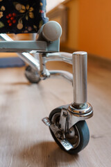 Close-Up of a Wheel from a Stylish Floral Stroller on a Wooden Floor