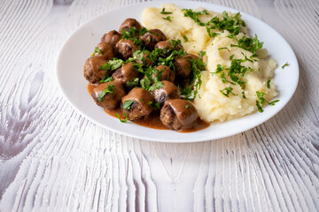 Swedish Meatballs with Gravy Sauce on a plate with mashed potatoes on a wooden background