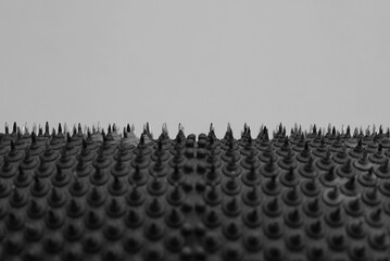Obraz premium Macro photo of a studded surface with multiple sharpened metal points with copy space over it 