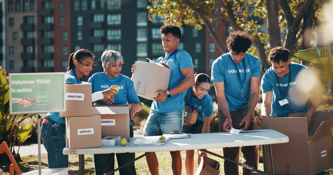 Outdoor, food drive and group of volunteers with help, goals and donations at charity event in park. Non profit, happy and NGO people in field in nature for community service project in collaboration