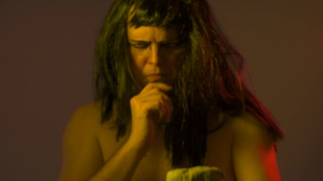 An ancient Egyptian man holds an Egyptian antiquity cuneiform clay tablet in his hands with ancient writings