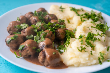 Swedish Meatballs with Gravy Sauce on a plate with mashed potatoes on a wooden background