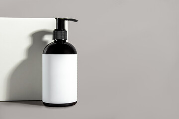 Bottle with gel for washing and box on gray background. Free space for text