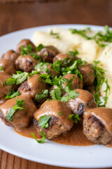 Swedish Meatballs with Gravy Sauce on a plate with mashed potatoes on a wooden background