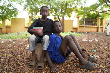 Two poor black African street children asking for alms - concept of child eploitation trough forced begging in African countries