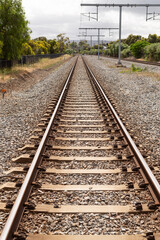 Fototapeta premium Outdoor view of railway tracks leading away from a suburban train station, Adelaide