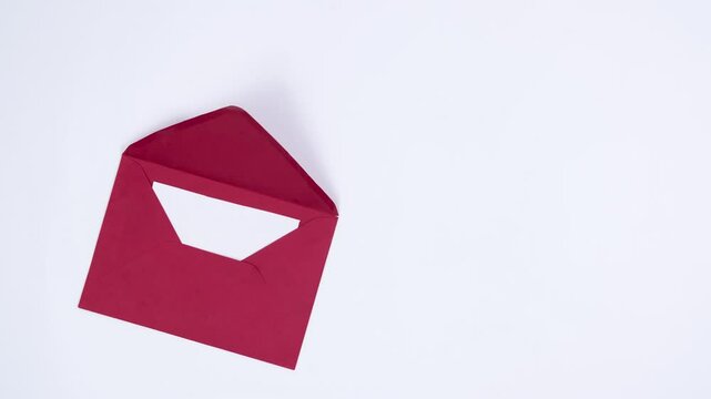White sheet appears from a red envelope. Template for text or design. Greeting card for Christmas or another holiday. White background. Copy space.
