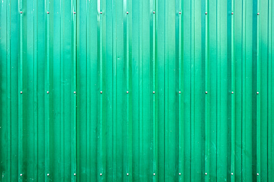 Green corrugated fiberglass siding bolted on to the exterior wall of a building