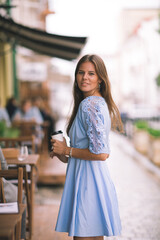 Obraz premium Caucasian attractive young woman walking out the door of a cafe.