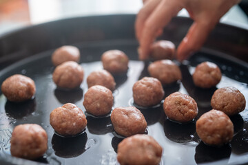 Round Swedish meatballs on a black tray	