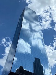 Glass facade of the building with a blue sky and white clouds