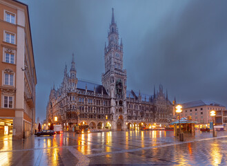 The illuminated New Town Hall at Marienplatz in Munich, Germany, during a rainy evening. © Kavalenkava