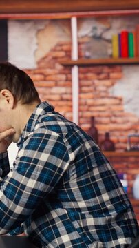 Coder at workstation programming on PC, writing lines of code, using development tools, feeling stressed. Man in home office having deadline, stressed to finish debugging software, camera B