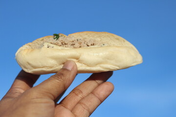 Vietnamese bread in hand on sky background