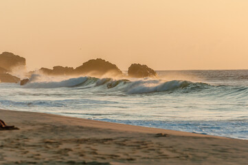 Twilight presents the gentle breeze of the strong wind, while the waves of the sea reflect the golden glow of the sun. The sand is touched by the spray of the water, on the beautiful beaches of Noronh