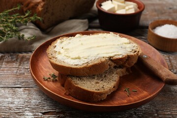 Fresh bread with butter on wooden table, closeup