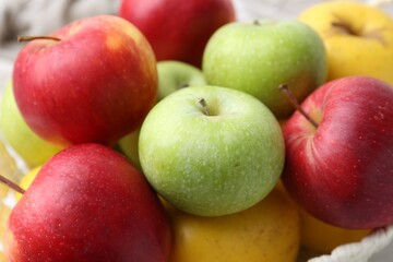 Different whole ripe apples in basket, closeup