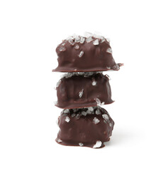 Stack of tasty chocolate candies with salt isolated on white
