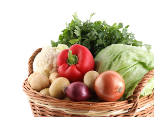 Different ripe vegetables in wicker basket isolated on white