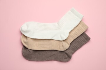 Different soft socks on pink background, flat lay